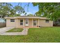 Charming single-story home with a welcoming porch, landscaped yard, and brick facade at 1116 Jadewood Ave, Clearwater, FL 33759