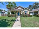 Charming bungalow with a blue front door and well-manicured lawn and landscaped garden at 1119 Highland S St, St Petersburg, FL 33701