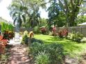Beautiful backyard oasis featuring lush landscaping, brick pavers, and a privacy fence at 1212 Rosewood St, Largo, FL 33770