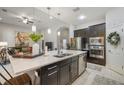 Open-concept kitchen with stainless appliances, quartz countertops, and dark wood cabinets overlooking the living area at 13821 Moonstone Canyon Dr, Riverview, FL 33579