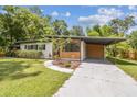 Charming single story home featuring a well maintained lawn and a covered carport at 1402 E Mimosa Dr, Plant City, FL 33563