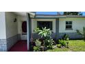 Inviting front porch with decorative plants, tiled floor and a view of the front lawn at 1583 Eunice Ln, Clearwater, FL 33756