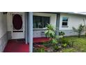 Inviting front porch with decorative plants, tiled floor and a view of the front lawn at 1583 Eunice Ln, Clearwater, FL 33756