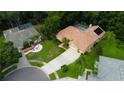 An aerial view showcases the property's tile roof, long driveway, manicured lawn, and verdant landscaping at 1827 Foxboro Ct, Oldsmar, FL 34677