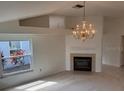 Cozy living room featuring fireplace, bright windows, chandelier, and view to adjacent rooms at 1922 Blue Sage Ct, Brandon, FL 33511