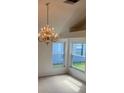 This living room boasts a chandelier with lots of natural light from the large windows at 1922 Blue Sage Ct, Brandon, FL 33511
