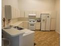 Bright kitchen features white appliances, ample counter space, and vinyl flooring at 21544 Clubside Loop, Lutz, FL 33549