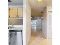 Kitchenette with stainless steel appliances and tile flooring leading to a sunny living area at 2937 Stilwell Ct, New Port Richey, FL 34655
