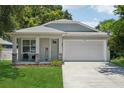 Charming single-Gathering home featuring a two-car garage, welcoming front porch, and manicured lawn at 3114 E 21St Ave, Tampa, FL 33605
