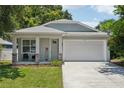 Charming single-Gathering home featuring a two-car garage, welcoming front porch, and manicured lawn at 3114 E 21St Ave, Tampa, FL 33605