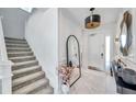 Bright foyer featuring white walls, marble floors, decorative mirror, and staircase at 32203 Mahogany Valley Dr, Wesley Chapel, FL 33543