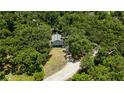 A secluded two-story home is surrounded by lush greenery, with a long private driveway at 34147 Ringwalt Dr, Dade City, FL 33523