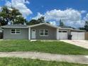 Charming single-story home with a stone facade, manicured lawn, an attached garage and a driveway at 3803 43Rd N Ave, St Petersburg, FL 33714