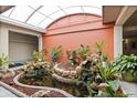 Picturesque atrium with lush greenery, water feature, and koi pond at 450 Treasure Isle Causeway # 411, Treasure Island, FL 33706