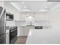 Updated kitchen featuring stainless steel appliances, white cabinetry, and tile backsplash at 450 Treasure Isle Causeway # 411, Treasure Island, FL 33706