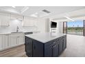 Bright kitchen with white cabinetry, quartz countertops, and a large center island with seating at 450 Treasure Isle Causeway # 411, Treasure Island, FL 33706