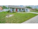 Inviting single-story home features a well-manicured lawn and freshly painted exterior under a sunny sky at 4518 Ashmore Dr, Tampa, FL 33610