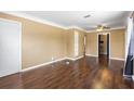 Spacious living room featuring wood flooring, a ceiling fan, and a built in shelving unit at 525 38Th S St, St Petersburg, FL 33711