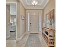 Bright foyer featuring tile flooring, decor shelving, and a view into the main bedroom at 5320 Morey Farms Loop, Palmetto, FL 34221