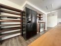 Open kitchen layout with black refrigerator, custom wooden shelving and modern appliances at 5507 Casino Dr, Holiday, FL 34690
