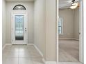 Bright foyer featuring tile floors, a decorative glass front door and a view into the adjacent bedroom at 5962 Lexington Dr, Parrish, FL 34219