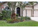 Close-up of the home's exterior and front yard showcasing landscaping, a three car garage and stone accents at 5962 Lexington Dr, Parrish, FL 34219