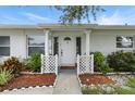Inviting front entrance featuring white pillars, well-manicured landscaping, and a charming walkway at 6119 31St N Ave, St Petersburg, FL 33710