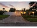 Charming single-story home with well-maintained lawn, fenced yard, and a spacious driveway illuminated by the sunset at 6119 31St N Ave, St Petersburg, FL 33710