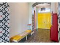 Bright foyer with decorative walls, a stylish bench, and vibrant yellow double doors at 6817 Ebb Tide Ave, Apollo Beach, FL 33572
