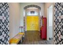 Striking foyer with yellow double doors, unique wall designs, and a colorful bench at 6817 Ebb Tide Ave, Apollo Beach, FL 33572