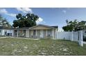 View of the house showcasing a white picket fence and an inviting front porch with classic design elements at 7206 Reindeer Rd, Tampa, FL 33619