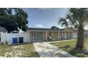 Front view of the house featuring well-maintained landscaping, a concrete driveway, and a cozy front porch area at 7206 Reindeer Rd, Tampa, FL 33619