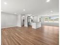 Bright, open-concept living room with gleaming hardwood floors, neutral paint, and plenty of natural light at 7571 Ridge Rd, Seminole, FL 33772