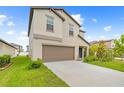 Attractive two-story home featuring a two-car garage, green lawn, and beautifully landscaped front yard at 81 Rain Lily Ave, Spring Hill, FL 34609