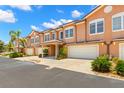 Townhouses featuring two-car garages, tiled roofs, and manicured lawns, perfect for comfortable living at 829 Date Palm Ln, St Petersburg, FL 33707
