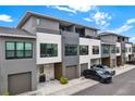 Modern townhomes showcasing gray and white exterior with individual garages, offering stylish urban living at 8714 Palm Ranches Pl, Tampa, FL 33614