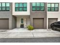 Close-up view of a contemporary townhome exterior with an attached garage, tidy landscaping, and modern accents at 8714 Palm Ranches Pl, Tampa, FL 33614