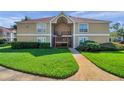 Attractive two-story condo with a charming walkway entrance and lush green lawn at 9481 Highland Oak Dr # 806, Tampa, FL 33647