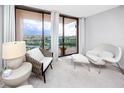 Cozy sitting area with chairs and a table offering a view of the balcony and beyond at 1 Key Capri # 606W, Treasure Island, FL 33706