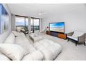 Bright living room with plush white sofa, modern furniture, and sliding glass doors to the balcony at 1 Key Capri # 606W, Treasure Island, FL 33706