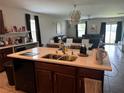 Modern kitchen island with a sink and ample counter space, perfect for entertaining at 10108 Rosemary Leaf Ln, Riverview, FL 33578