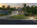 Evening shot of a well-kept single-story home, showcasing its tidy lawn and welcoming facade at 11144 Paradise Point Way, New Port Richey, FL 34654