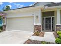 Close-up view of a home's facade, highlighting the two-car garage and decorative stone accents at 11144 Paradise Point Way, New Port Richey, FL 34654