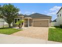 Charming single-Gathering home featuring a brick driveway, two-car garage, and mature landscaping at 12322 Eagle Swoop Pl, Riverview, FL 33579