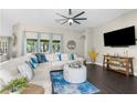 Expansive living room boasts a large sectional sofa, stylish ottoman, and scenic views through wide windows at 12333 Harris Hawk Rd, Weeki Wachee, FL 34614