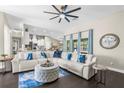 Bright living room with a white sectional, stylish decor, and an open layout leading to the kitchen at 12333 Harris Hawk Rd, Weeki Wachee, FL 34614