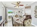 Cozy dining area featuring a decorative ceiling fan, wood-look tile, and sliding glass doors to backyard at 12476 81St Ct, Seminole, FL 33772