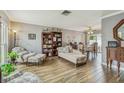 Open living room with wood-look tile flooring, natural lighting, and comfortable seating with vintage decor at 12476 81St Ct, Seminole, FL 33772
