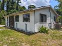 Exterior of the home showing siding and an air conditioning unit surrounded by greenery at 12704 Lacey, New Port Richey, FL 34654