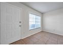 Bright entryway featuring tile flooring, a white door, and a window allowing natural light to fill the space at 1302 Twilridge Pl, Brandon, FL 33511